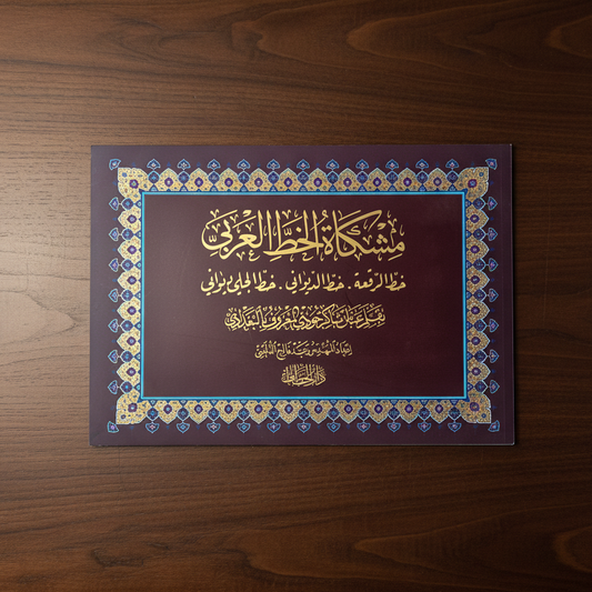 A rectangular decorative plaque or book cover with Arabic calligraphy, placed on a dark brown wooden surface. The center panel is deep burgundy with gold calligraphy, surrounded by a blue and gold ornamental border.